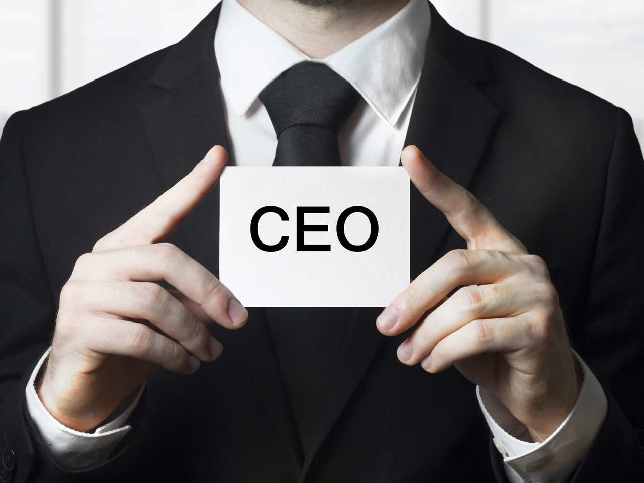 businessman holding small white sign ceo