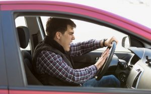 Closeup portrait of aggressive male driver honking in traffic jam